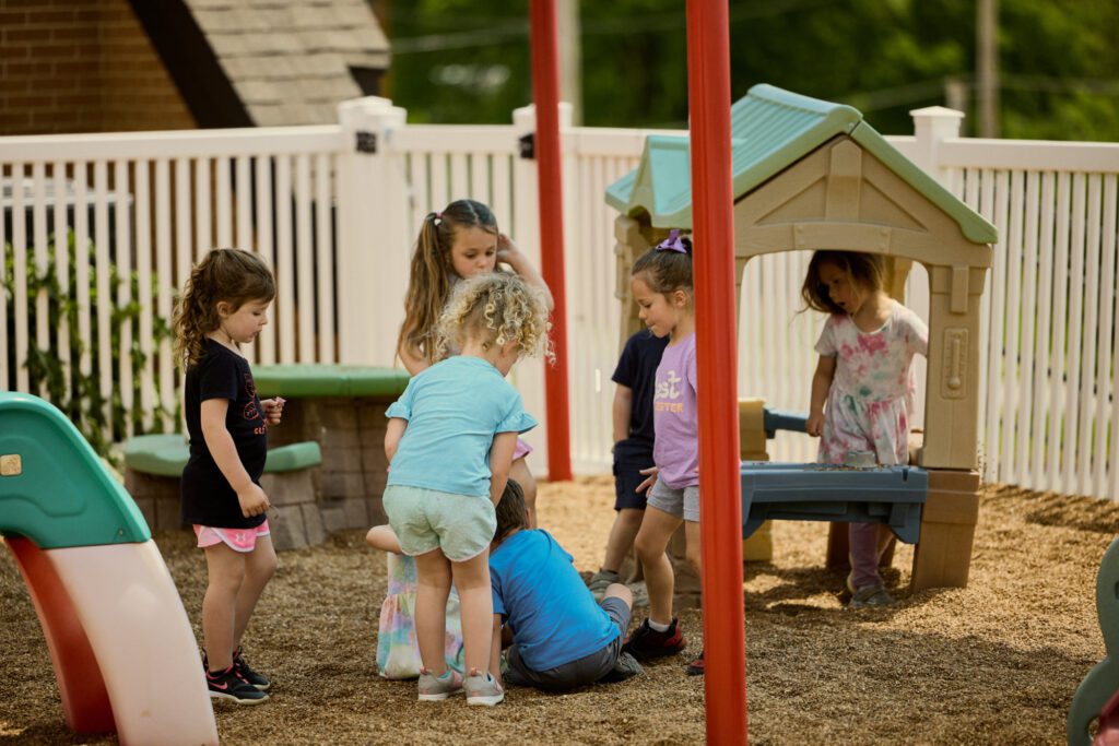 Group of early elementary students play pretend outside Abiding Savior Lutheran School.