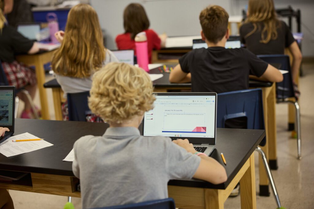 Middle school students at Abiding Savior Lutheran School work at laptops in classroom.